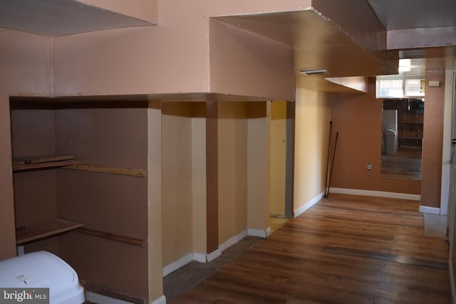 hall featuring dark wood-style floors and baseboards