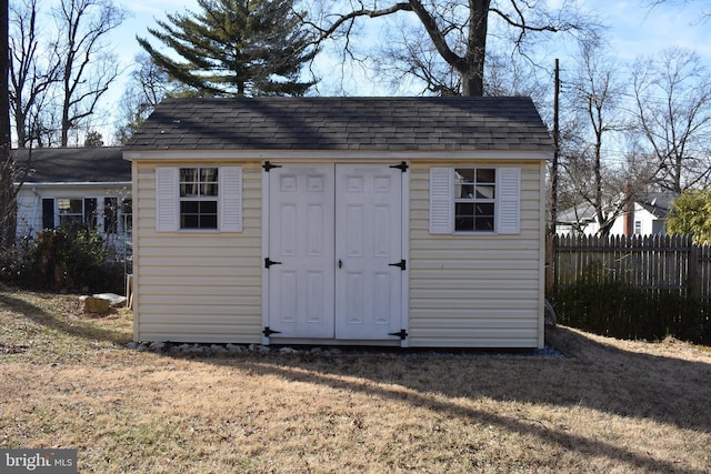 view of shed featuring fence