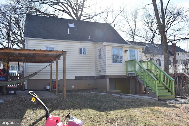 back of house featuring roof with shingles