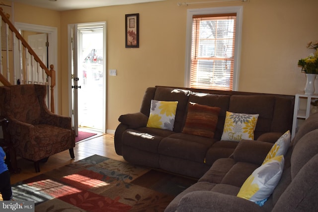 living room with light wood-type flooring and stairs