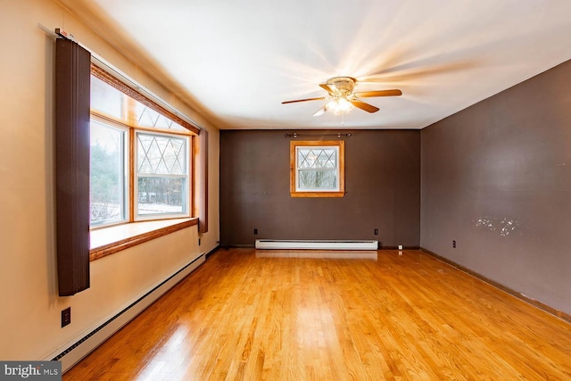 empty room with light wood finished floors, a baseboard radiator, and a ceiling fan