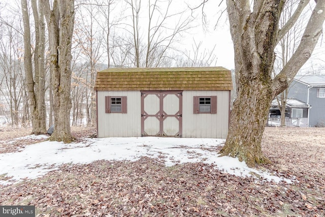 snow covered structure with a shed and an outbuilding