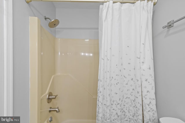 bathroom featuring toilet and shower / bath combo with shower curtain