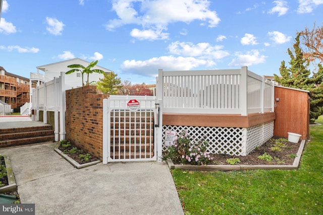 exterior space featuring a deck, fence, and a gate