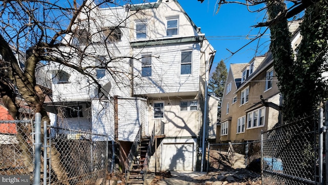 view of front of property featuring an attached garage, stairway, and fence