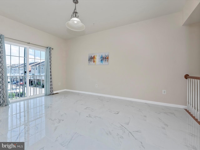 spare room with marble finish floor and baseboards