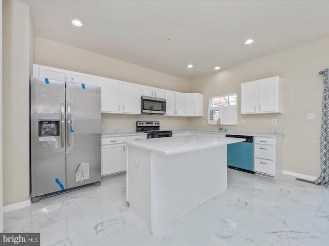 kitchen featuring marble finish floor, appliances with stainless steel finishes, white cabinets, and a center island