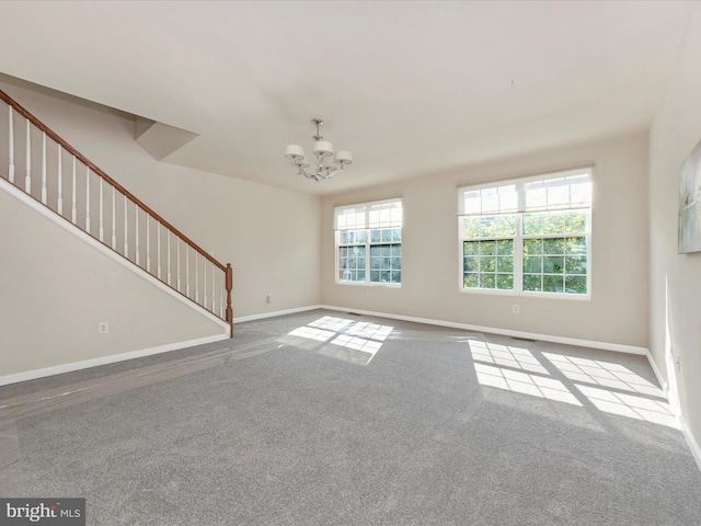 unfurnished living room featuring baseboards, stairway, light carpet, and an inviting chandelier