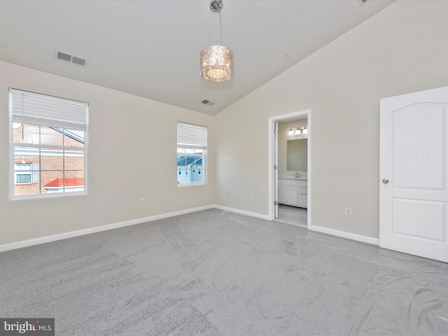 unfurnished bedroom with lofted ceiling, light colored carpet, and multiple windows