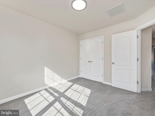 unfurnished bedroom with carpet floors, a closet, visible vents, and baseboards