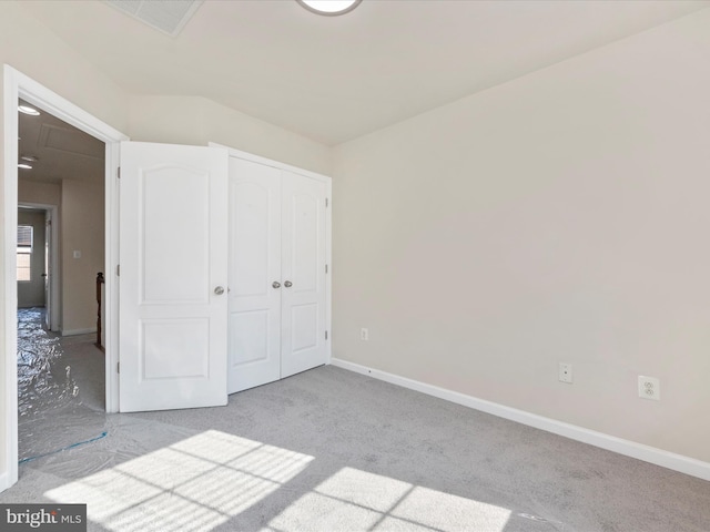 unfurnished bedroom featuring light carpet, visible vents, baseboards, and a closet