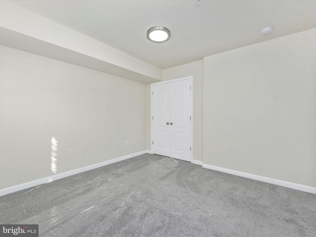 unfurnished room with baseboards and light colored carpet