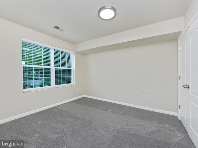 carpeted spare room with baseboards and visible vents