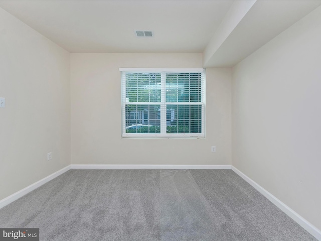 unfurnished room with baseboards, visible vents, and carpet flooring