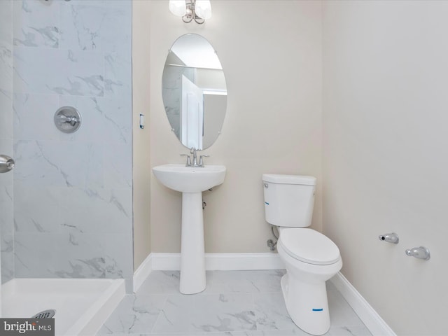 full bathroom with marble finish floor, toilet, a tile shower, a sink, and baseboards