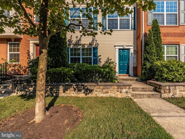 view of front of home featuring brick siding and a front lawn