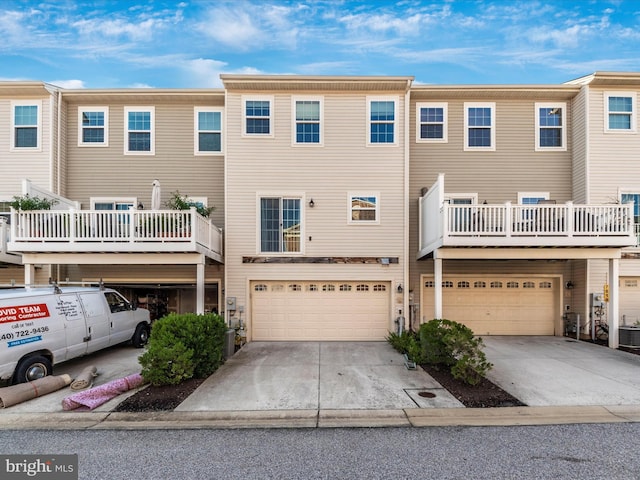 townhome / multi-family property featuring driveway, an attached garage, and central AC unit