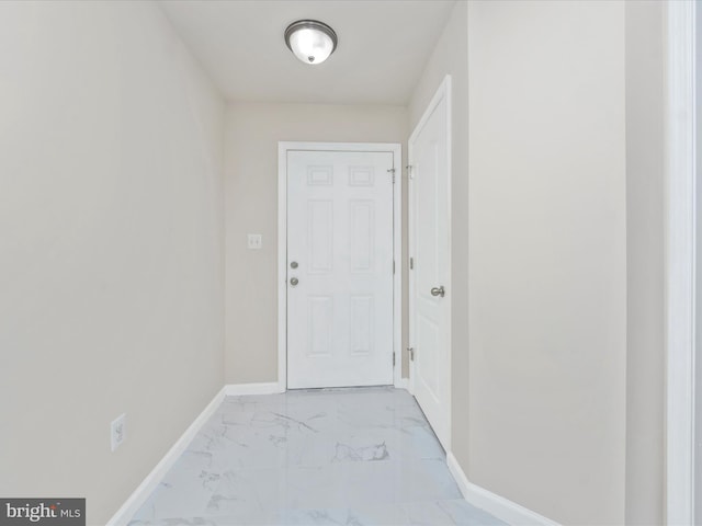 entryway with marble finish floor and baseboards