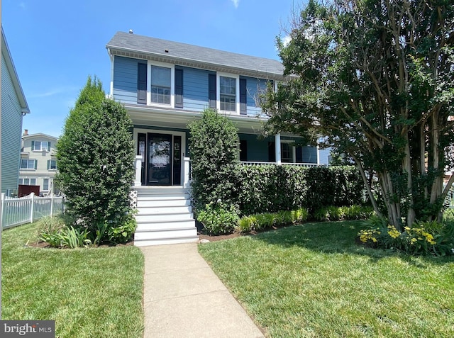 view of front facade featuring a porch, a front yard, and fence