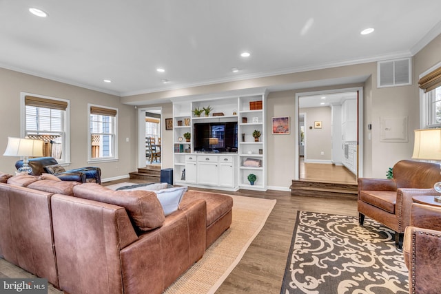 living area featuring ornamental molding, wood finished floors, visible vents, and recessed lighting