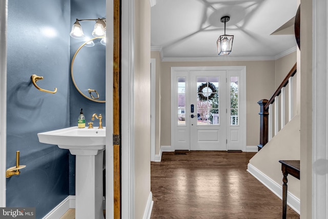 entryway with stairway, baseboards, ornamental molding, and wood finished floors