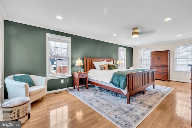 bedroom with light wood-style floors and crown molding