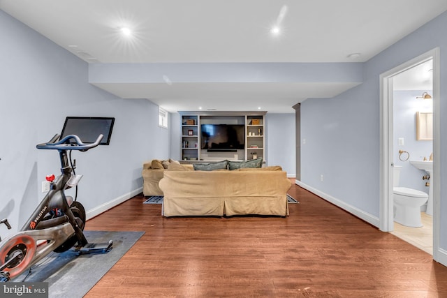 workout area featuring built in features, recessed lighting, baseboards, and wood finished floors