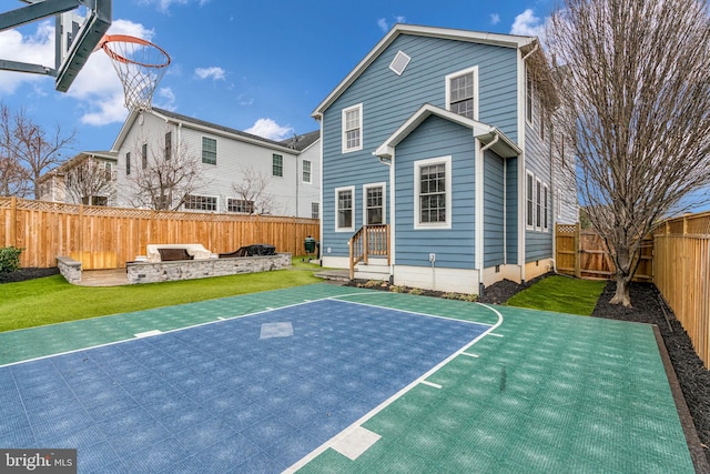 view of sport court with a fenced backyard, a lawn, and basketball hoop