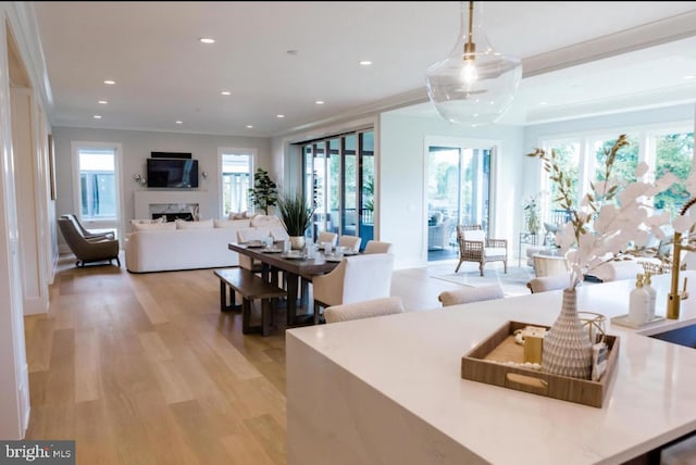 living area featuring light wood-style floors, recessed lighting, a fireplace, and ornamental molding