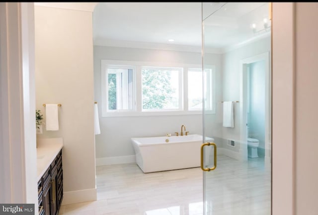 full bathroom featuring ornamental molding, a soaking tub, vanity, and toilet