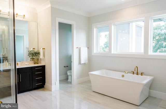 bathroom with toilet, baseboards, vanity, and crown molding