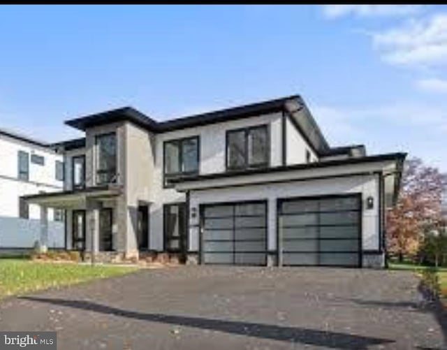 view of front of house with driveway, an attached garage, and stucco siding