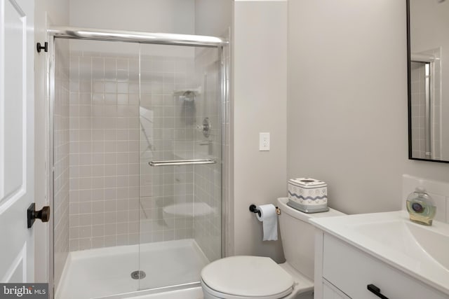 bathroom featuring a stall shower, vanity, and toilet