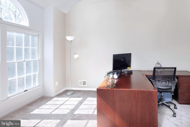 carpeted home office featuring visible vents and baseboards