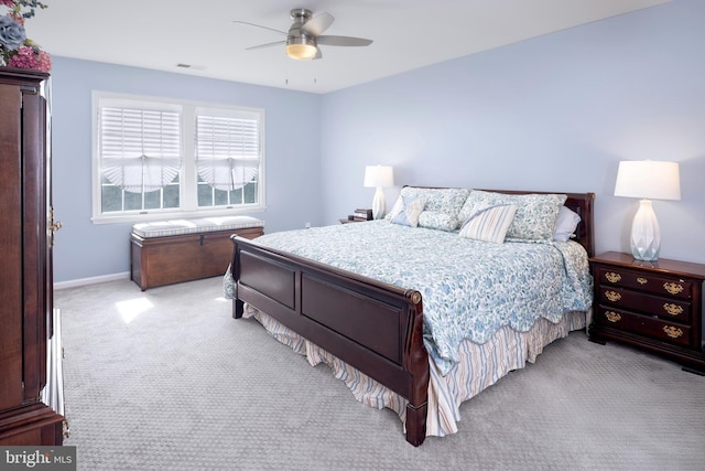 bedroom with light carpet, ceiling fan, visible vents, and baseboards