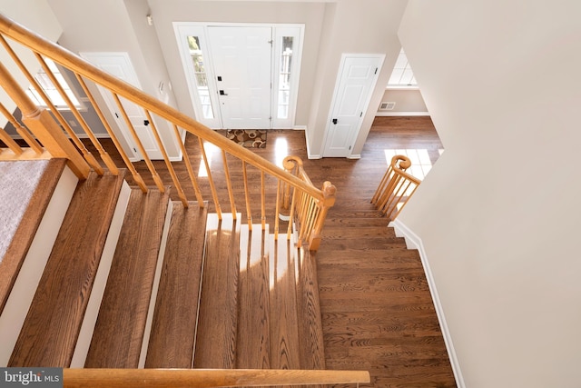 stairs featuring visible vents, baseboards, and wood finished floors