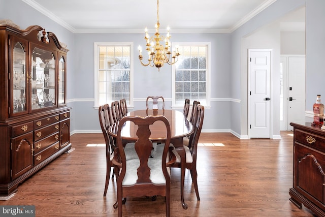 dining space featuring a chandelier, crown molding, dark wood finished floors, and baseboards