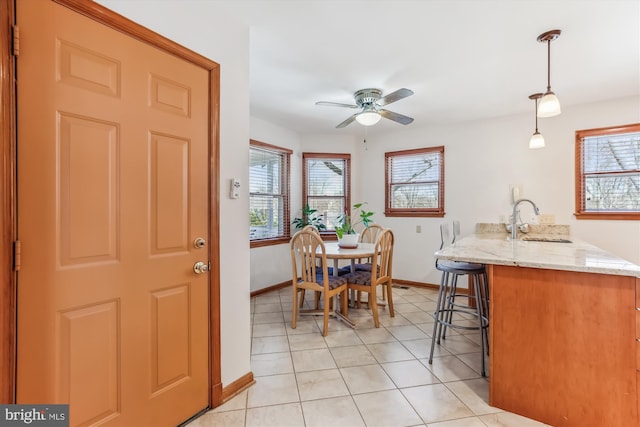 dining space featuring a wealth of natural light, baseboards, a ceiling fan, and light tile patterned floors