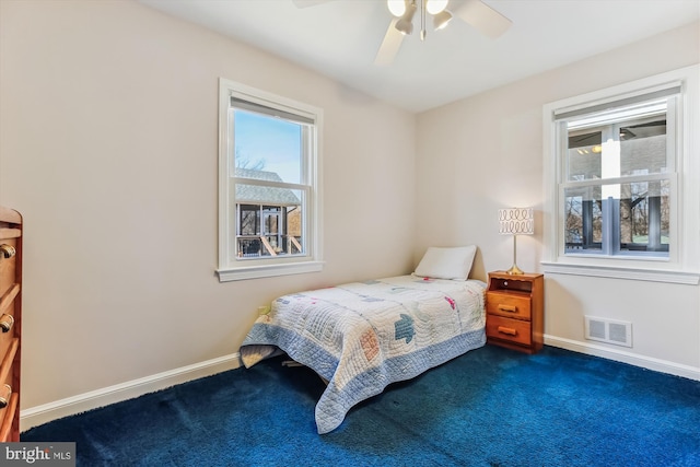 bedroom featuring dark colored carpet, visible vents, baseboards, and ceiling fan