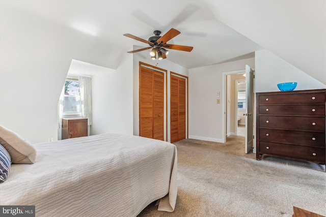 carpeted bedroom featuring baseboards, two closets, and ceiling fan