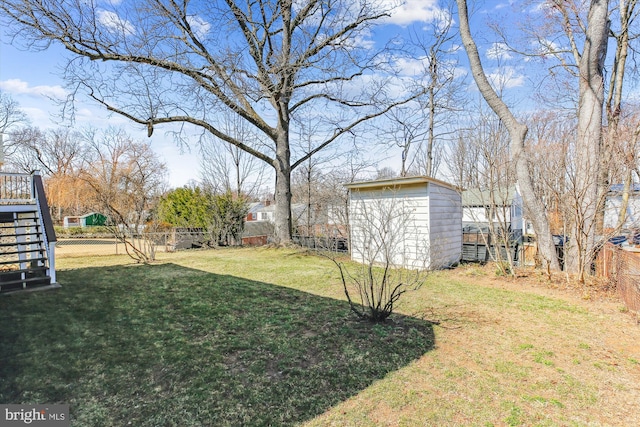 view of yard with stairway, an outbuilding, a storage shed, and fence