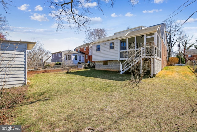 rear view of property with a lawn, stairs, fence, and a sunroom