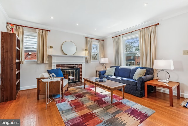 living room with baseboards, recessed lighting, a fireplace, ornamental molding, and hardwood / wood-style flooring