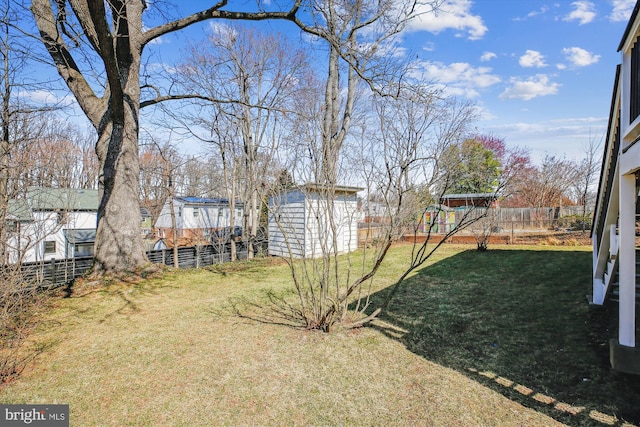 view of yard featuring a fenced backyard, a storage unit, and an outdoor structure