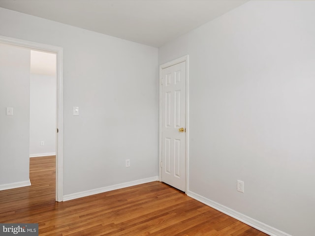 spare room with wood finished floors and baseboards