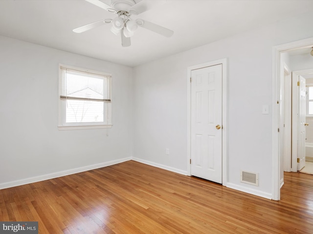 unfurnished bedroom featuring light wood-style flooring, a ceiling fan, visible vents, and baseboards