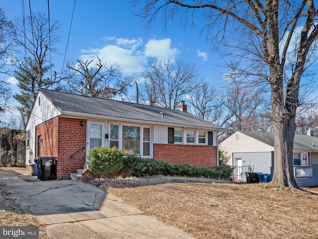 view of front of property with brick siding and a chimney