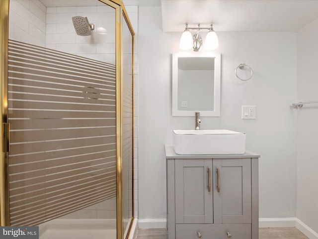 full bathroom with a stall shower, vanity, and baseboards