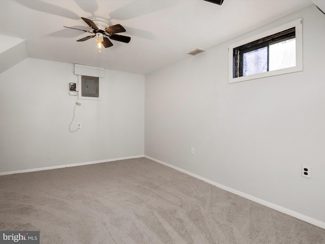 basement featuring visible vents, electric panel, baseboards, and carpet flooring