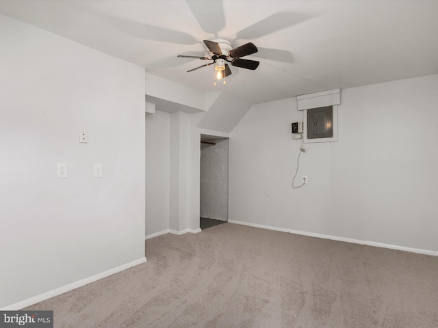 bonus room featuring baseboards, ceiling fan, electric panel, and light colored carpet